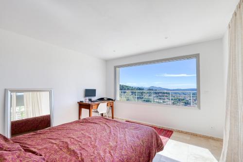 une chambre avec un lit et une fenêtre dans l'établissement Superbe villa au calme avec vue, à Ollioules