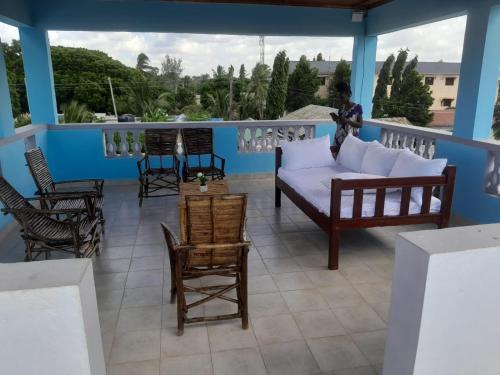 a living room with a couch and chairs on a balcony at Kelly Homes in Kilifi