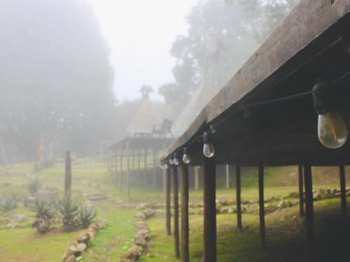 a building with a view of a field and a house at The Magical Teepee Experience in Hogsback