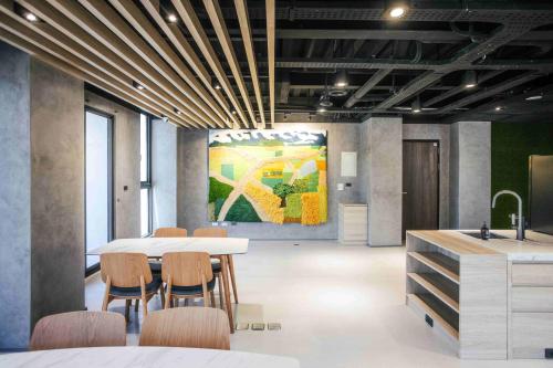 a conference room with a table and chairs and a painting at kaori B&B in Chishang