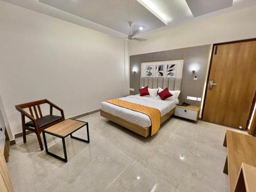 a hotel room with a bed and a chair at Hotel Sunlight in Puducherry