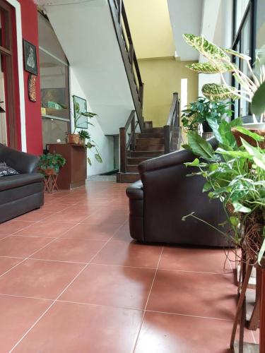 a lobby with couches and potted plants and stairs at Lake Wave Hotel in Anuradhapura