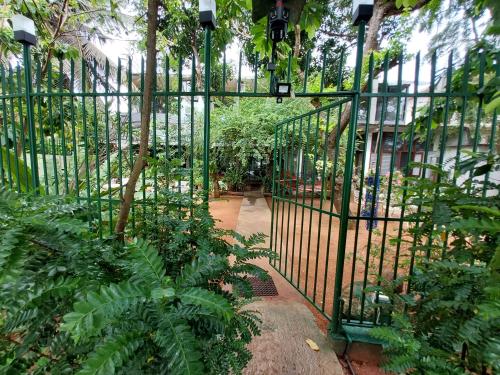 a green gate in a garden with plants at Lake Wave Hotel in Anuradhapura