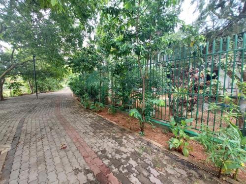 a wrought iron fence next to a brick road at Lake Wave Hotel in Anuradhapura
