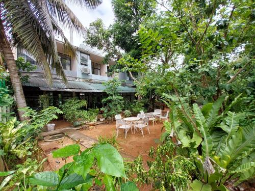 a garden with tables and chairs in front of a building at Lake Wave Hotel in Anuradhapura