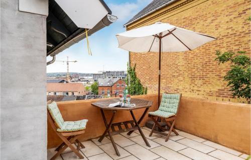 a table and chairs on a balcony with an umbrella at One-Bedroom Apartment In Svendborg in Svendborg