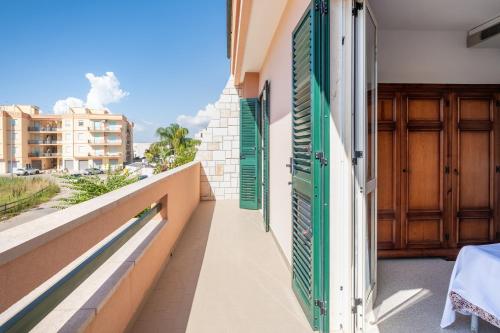 a balcony with green shutters on a building at I Love Baia Verde spa in Baia Verde