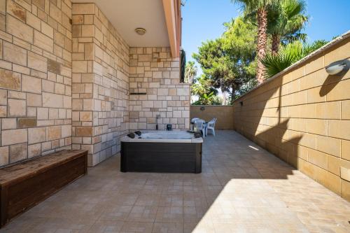 a bathroom with a bath tub in a brick wall at I Love Baia Verde spa in Baia Verde