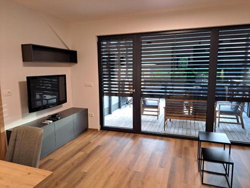 a living room with a dining table and a large window at S&B's RETREAT in Godovič