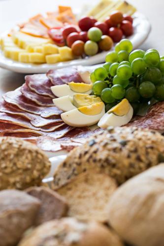 a plate of food with grapes and other foods at Old Parish House in Bled