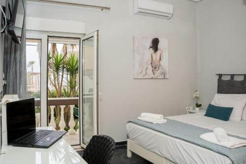 a bedroom with a bed and a laptop on a desk at Chrispa's House Beachfront Bliss & Stunning Views 50m from the beach in Rethymno
