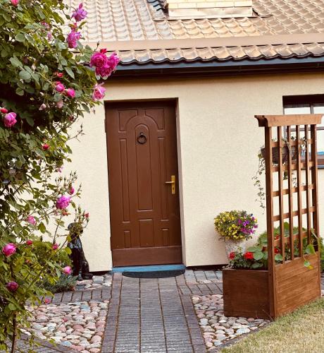 una porta marrone di una casa con fiori di Evija a Ventspils