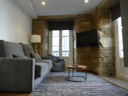a living room with a couch and a table at Apartamento foroplaza campo I in Lugo