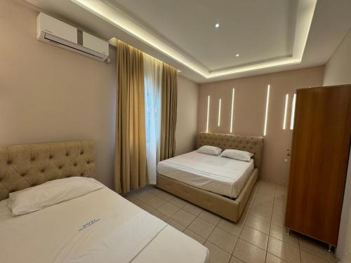 a hotel room with two beds and a window at Hotel Dragoi in Velipojë