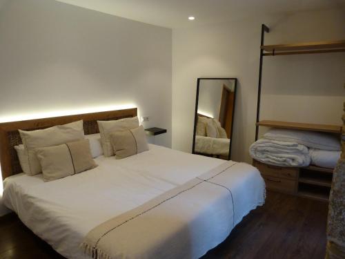 a bedroom with a large white bed and a mirror at Apartamento foroplaza campo I in Lugo