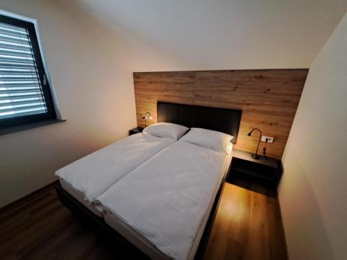a bedroom with a large white bed and a window at S&B's RETREAT in Godovič
