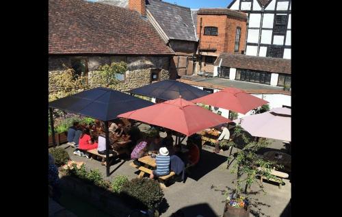 a group of people sitting at tables under umbrellas at The Bull Hotel in Ludlow