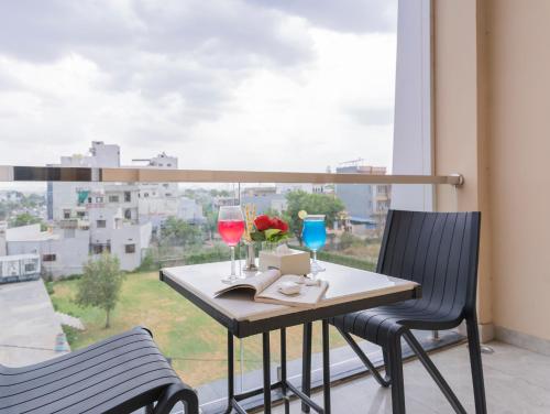 a balcony with a table and two glasses of wine at D Fortune Park in Udaipur