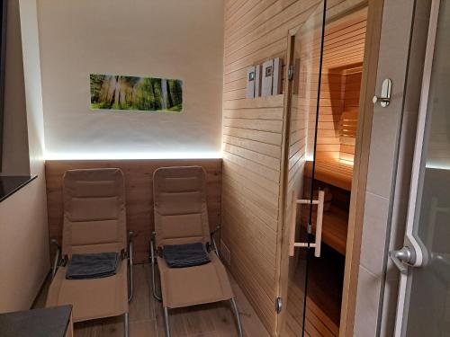 a tiny house with two chairs and a shower at S&B's RETREAT in Godovič