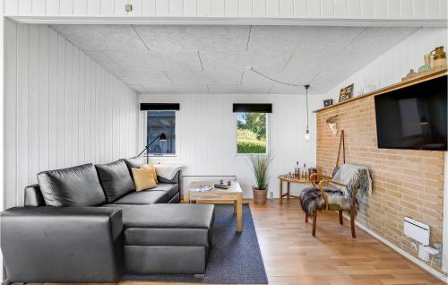 a living room with a couch and a table at Cozy Home In Vesløs With House Sea View in Øsløs