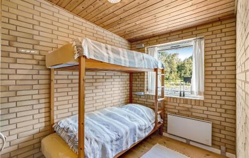a bedroom with a bunk bed in a brick wall at Cozy Home In Vesløs With House Sea View in Øsløs
