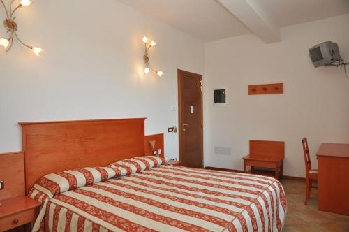 a bedroom with a large bed with a striped blanket at LOCANDA Mingaren in La Panighina