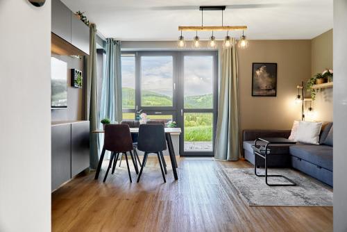 a living room with a table and chairs and a couch at Výhledy bez hranic by Mountain ways in Loučná pod Klínovcem