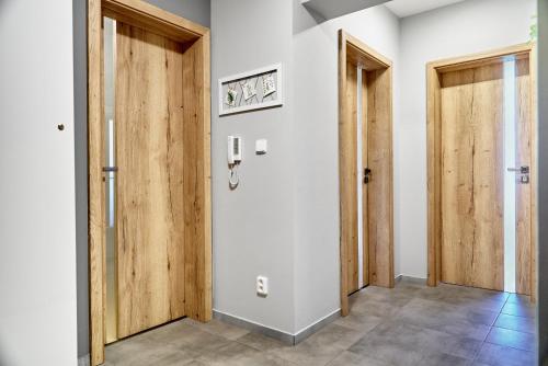 a hallway with two wooden doors and tile floors at Výhledy bez hranic by Mountain ways in Loučná pod Klínovcem