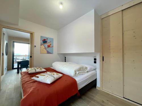 une chambre avec un lit avec deux oreillers dessus dans l'établissement Homency - Résidence Chalets du Golf - Albatros A203, à L'Alpe-d'Huez