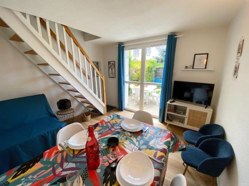 un salon avec une table et un escalier dans l'établissement CALLEA - Proche Men Dû, Jardin clos - T22, à Carnac