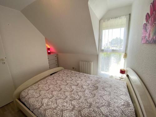 une petite chambre avec un lit et une fenêtre dans l'établissement CALLEA - Proche Men Dû, Jardin clos - T22, à Carnac