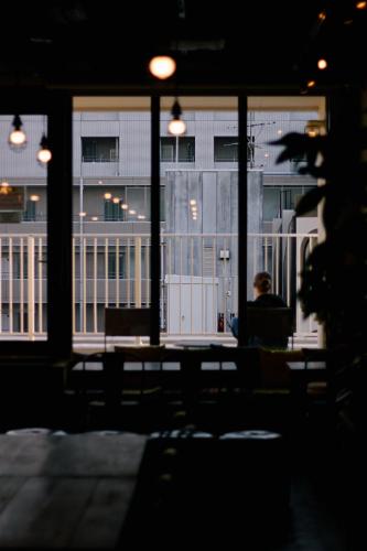 a person sitting in a chair in front of a window at WeBase Hakata Hostel in Fukuoka