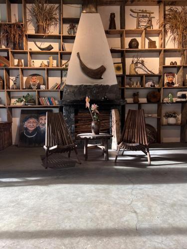 a room with a fireplace with two chairs and a table at Pavi garden in Sa Pa