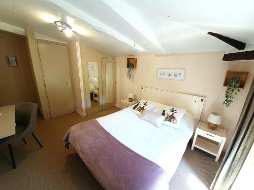 a bedroom with a bed and a desk and a table at Logis Hotel Le Prince Noir in Sérignac-sur-Garonne