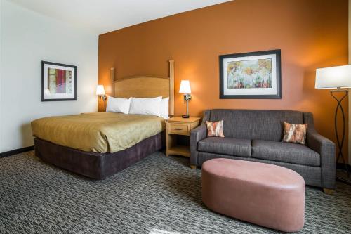 una camera d'albergo con letto e divano di MainStay Suites Sidney - Medical Center a Sidney