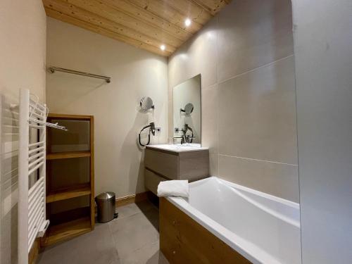 a bathroom with a tub and a sink at Homency - Résidence Daria-i-Nor 202 in L'Alpe-d'Huez