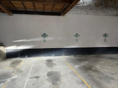 an empty parking lot with a white wall at Dupain & Dubeurre Appart'hôtel - Parking en supp in Limoges