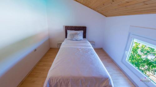 a large bed in a room with a window at Villa Pearl- with private pool in Blagaj
