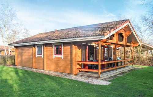 a small wooden house with a green yard at 3 Bedroom Cozy Home In Gramsbergen in Gramsbergen