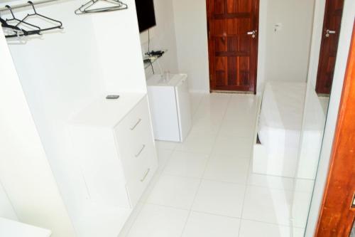 a white bathroom with a sink and a toilet at Hotel Americas in Fortaleza
