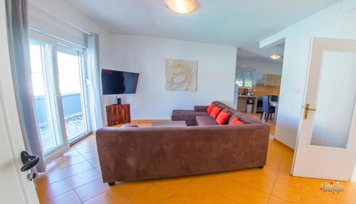 a living room with a brown couch and a television at Villa Pearl- with private pool in Blagaj