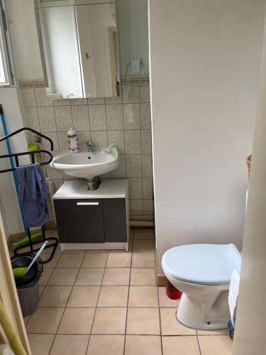 une salle de bain avec des toilettes blanches et un lavabo dans l'établissement Studio lumineux, à Corbeil-Essonnes