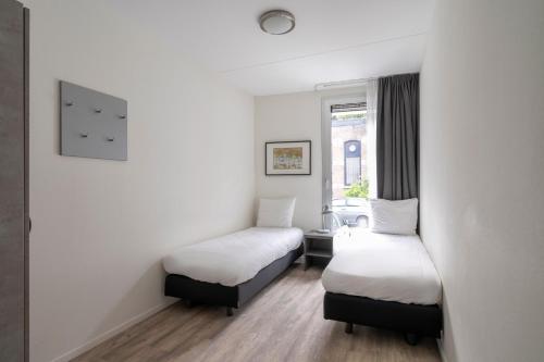 a room with two beds and a window at YAYS Amsterdam Prince Island by Numa in Amsterdam