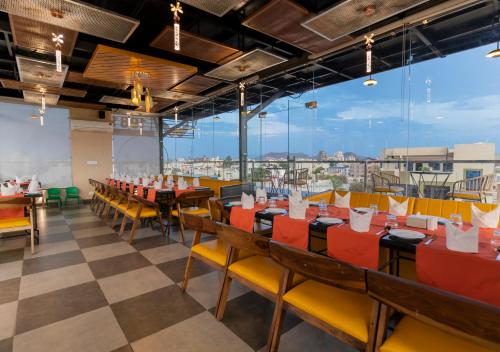 a dining room with tables and chairs and a large window at D Fortune Park in Udaipur