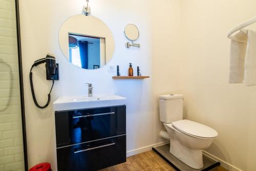 a bathroom with a toilet and a mirror at Dupain & Dubeurre Appart'hôtel - Parking en supp in Limoges