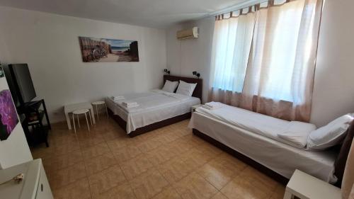 a hotel room with two beds and a window at S Apartment in Tsarevo