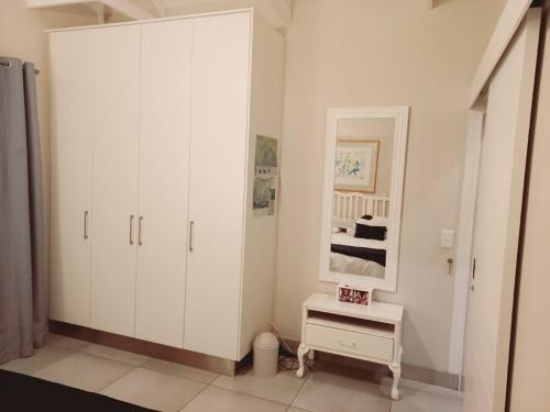 赫曼努斯Seashell Cottage的白色卧室设有大型白色橱柜