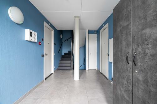 a hallway with blue walls and a staircase at YAYS Amsterdam Prince Island by Numa in Amsterdam