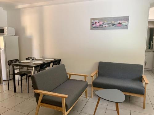 a living room with two chairs and a table at Le Mas des Bois in Le Muy