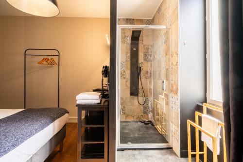 a bathroom with a shower and a bed in a room at Dupain & Dubeurre Appart'hôtel - Parking en supp in Limoges